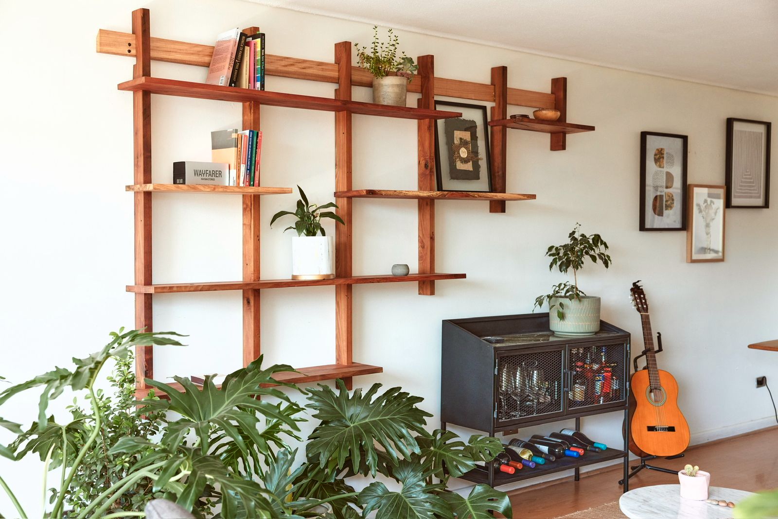 Repisa colgante de madera recuperada instalada en un living con plantas