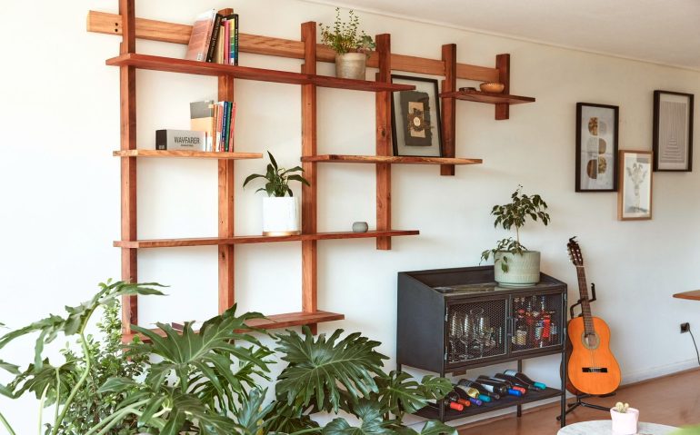 Repisa colgante de madera recuperada instalada en un living con plantas